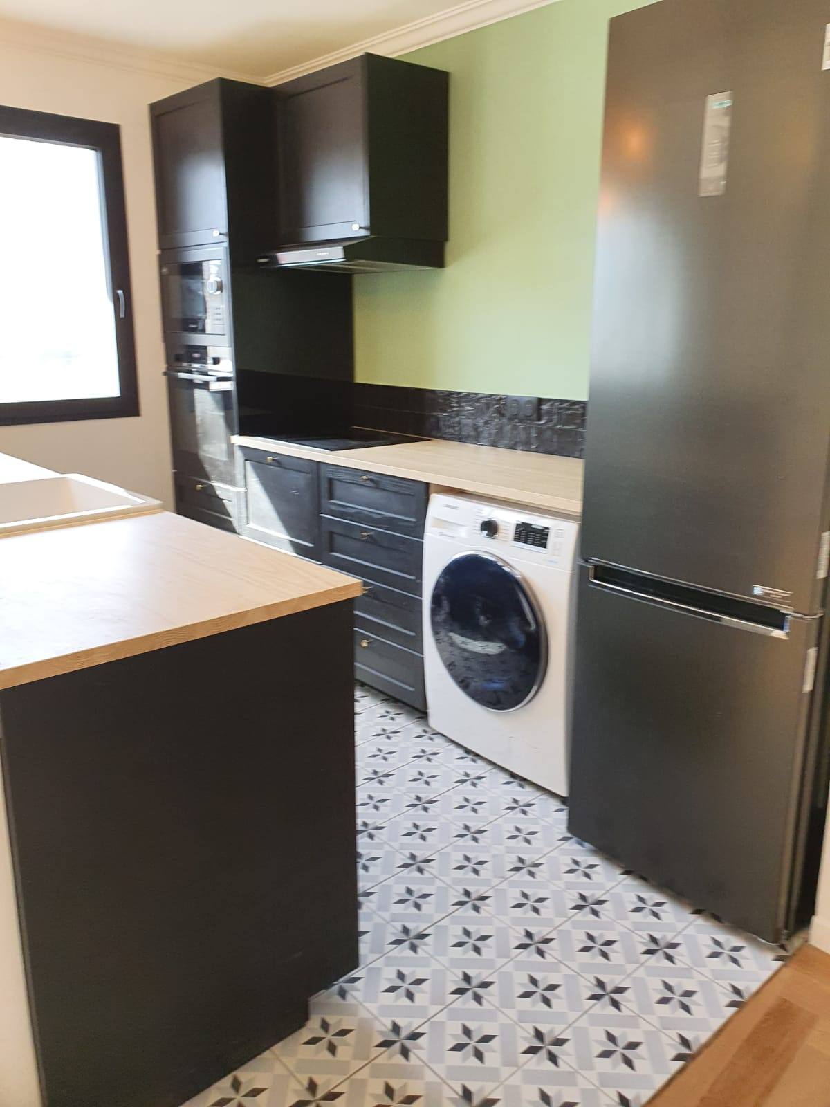Cuisine noire et sol en carreaux de ciment — appartement rénové à Saint-Ouen
