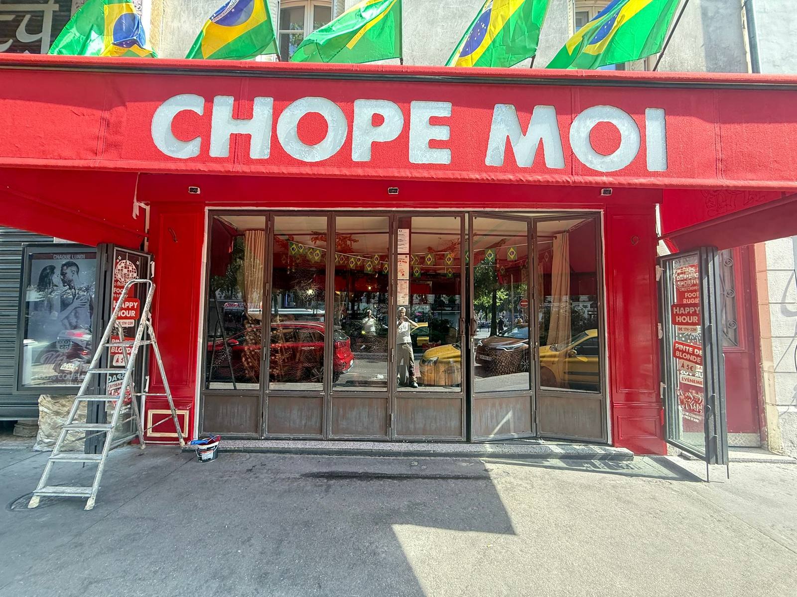 Devanture du bar-restaurant après travaux — façade repeinte en rouge, enseigne rafraîchie