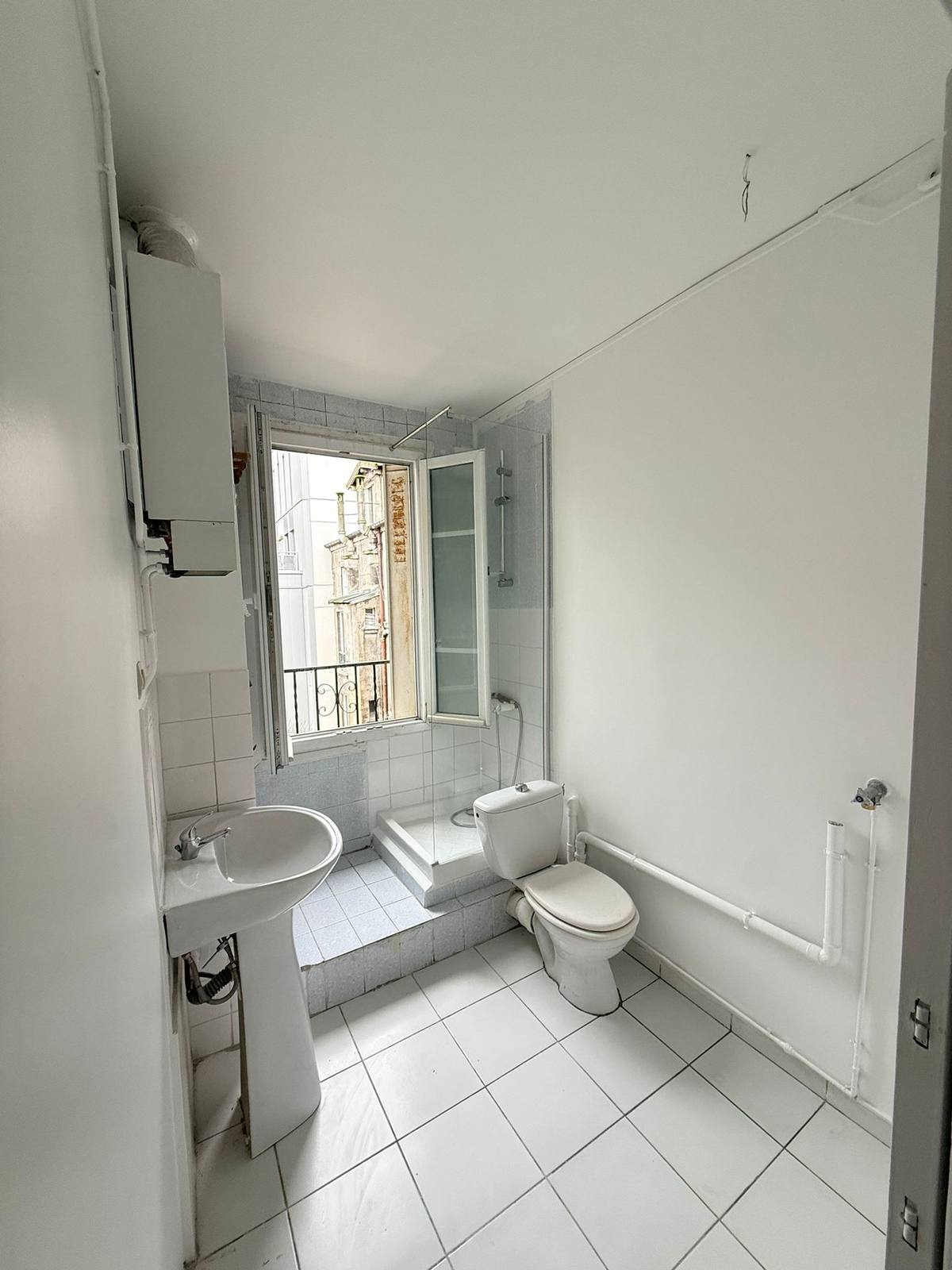 Salle d'eau après travaux — plafond repris, peinture et carrelage neufs