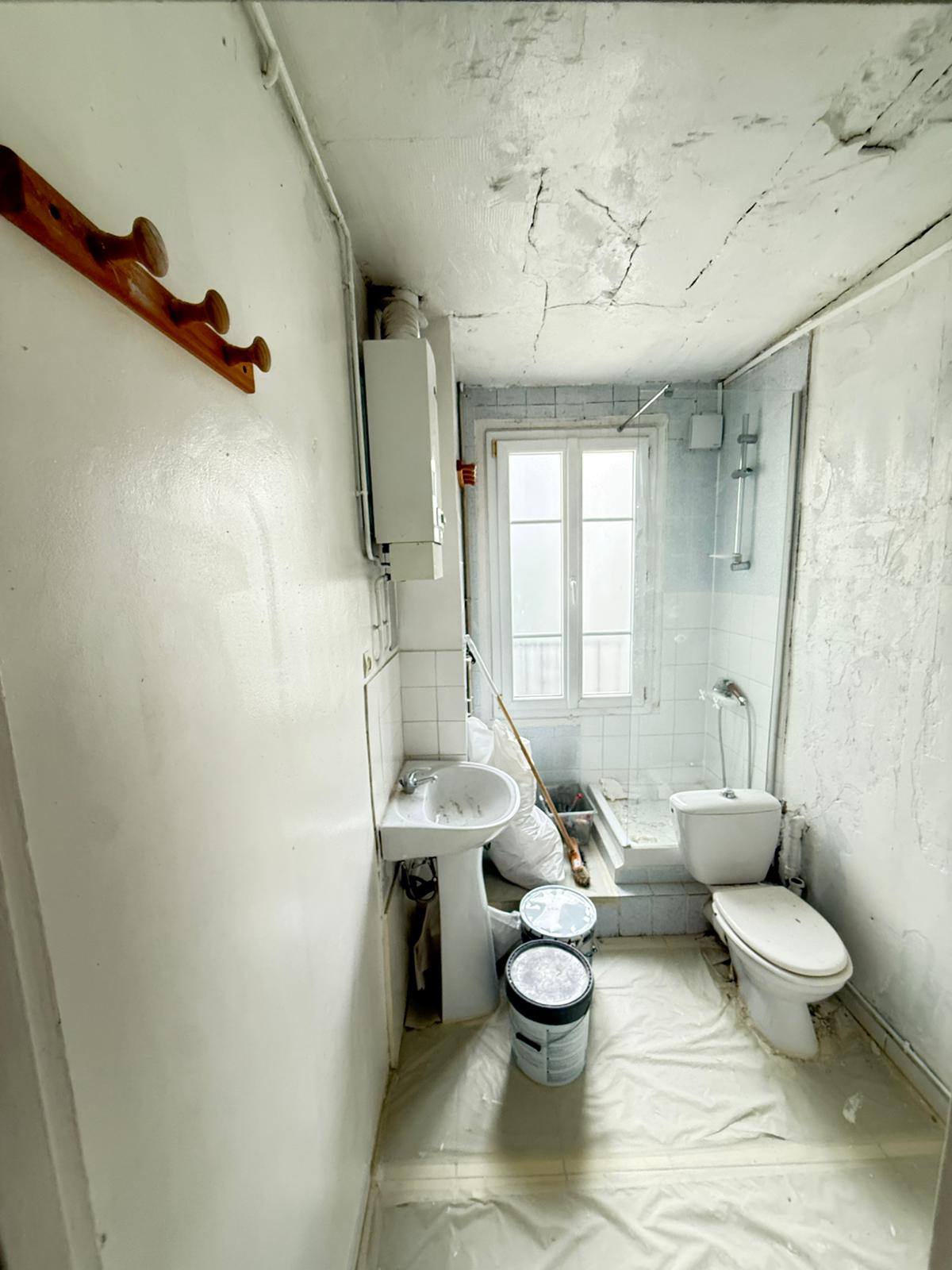 Salle d'eau avant travaux — plafond fissuré et dégradé